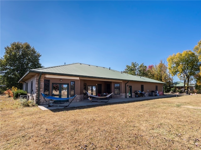 rear view of property with a patio and a lawn