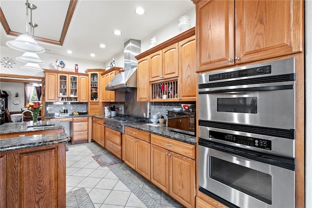 kitchen with appliances with stainless steel finishes, crown molding, dark stone countertops, and backsplash