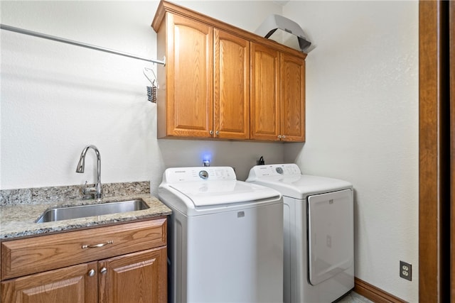 laundry area with cabinets, washer and dryer, and sink