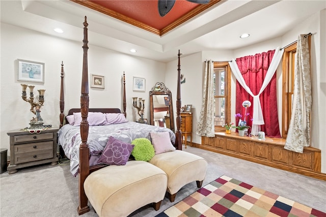 bedroom with ornamental molding, light colored carpet, and a raised ceiling