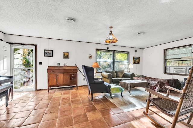 living area with cooling unit, plenty of natural light, and a textured ceiling