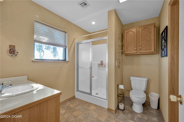 bathroom with vanity, toilet, and a shower with shower door