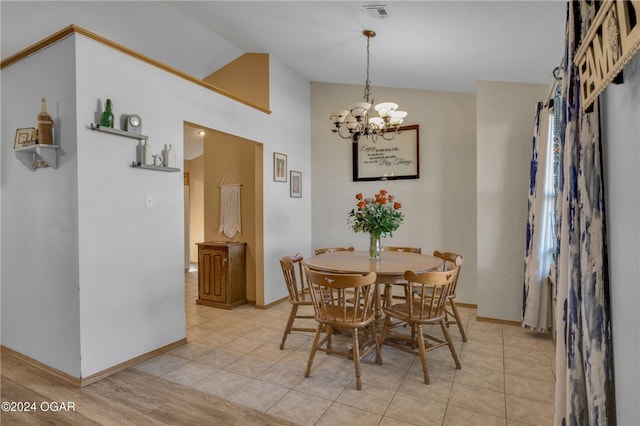 dining room featuring lofted ceiling, light hardwood / wood-style flooring, and a notable chandelier