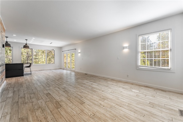 unfurnished living room featuring a healthy amount of sunlight and light hardwood / wood-style flooring