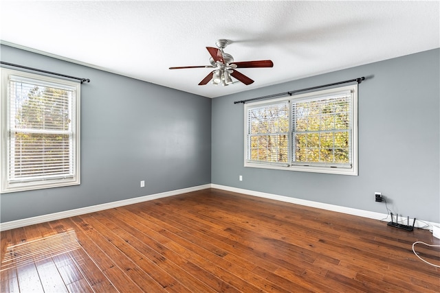 spare room featuring ceiling fan, hardwood / wood-style flooring, a textured ceiling, and plenty of natural light