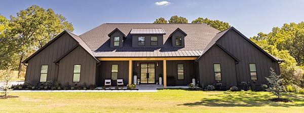 rear view of property featuring board and batten siding, a porch, and a lawn