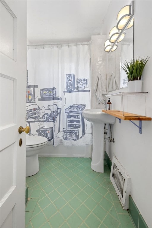 bathroom featuring shower / tub combo, toilet, and visible vents