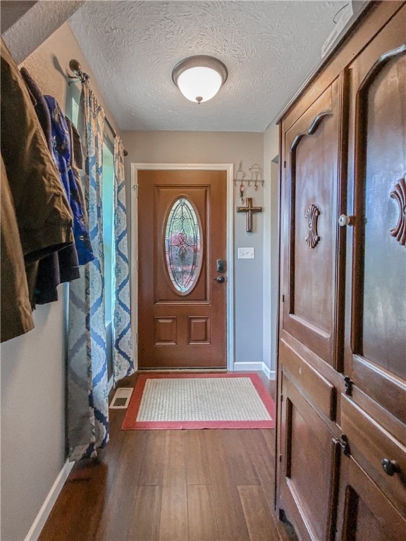 entryway featuring dark wood-type flooring and a textured ceiling