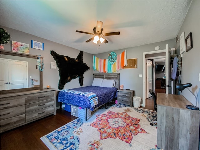 bedroom featuring a textured ceiling, dark wood-type flooring, and ceiling fan