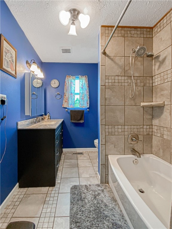 full bathroom featuring toilet, tile patterned flooring, tiled shower / bath, vanity, and a textured ceiling