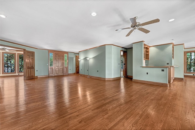 unfurnished living room with crown molding, hardwood / wood-style floors, and ceiling fan