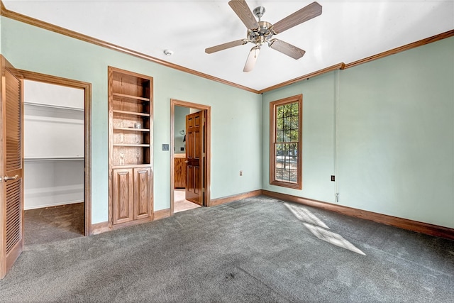 unfurnished bedroom with crown molding, dark colored carpet, a closet, and ceiling fan