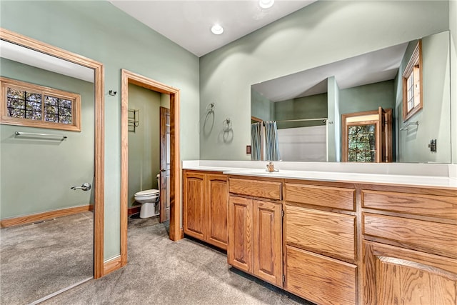 bathroom featuring toilet, walk in shower, and vanity