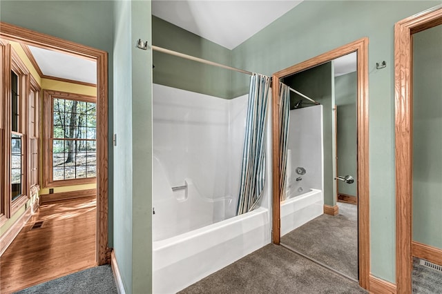 bathroom featuring wood-type flooring and shower / tub combo