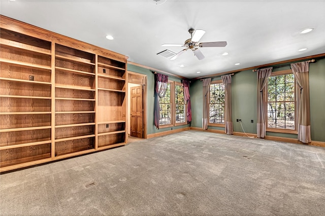 unfurnished living room with ceiling fan, ornamental molding, and carpet floors