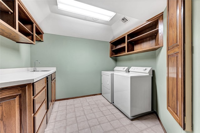 laundry room featuring cabinets, sink, and washer and clothes dryer