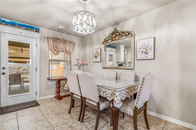 tiled dining space featuring a chandelier