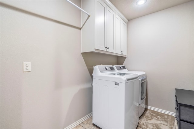 washroom with washing machine and clothes dryer, light tile patterned floors, and cabinets