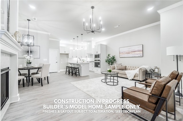 living room featuring light hardwood / wood-style flooring, crown molding, and sink