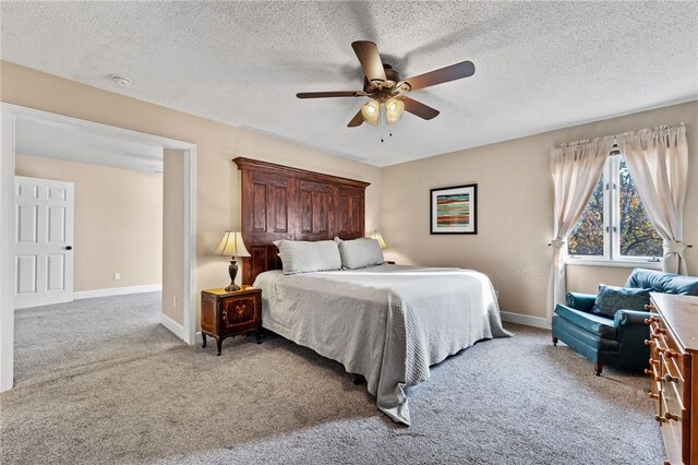 bedroom featuring light carpet, a textured ceiling, and ceiling fan