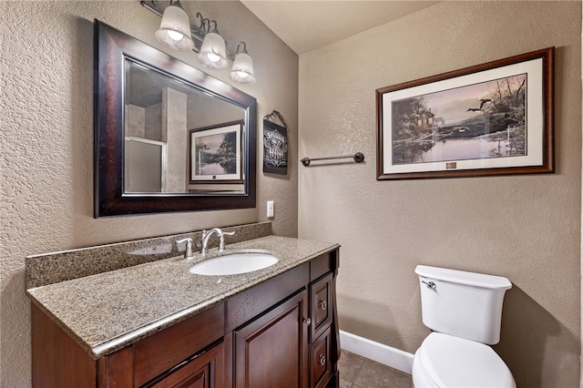 bathroom with tile patterned flooring, vanity, and toilet