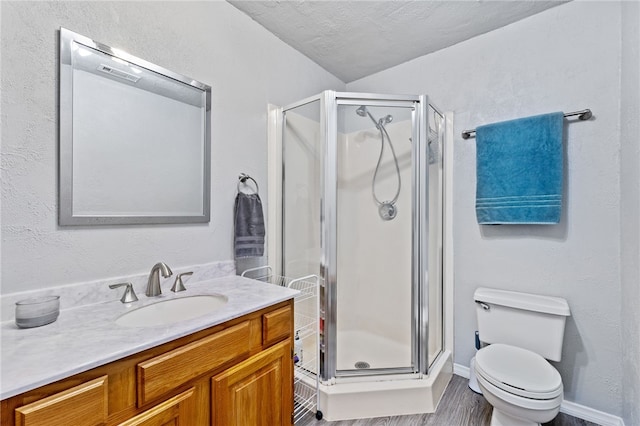 bathroom featuring hardwood / wood-style floors, vanity, a textured ceiling, toilet, and walk in shower