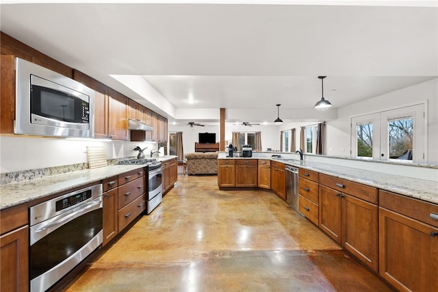 kitchen featuring decorative light fixtures, sink, ceiling fan, light stone counters, and stainless steel appliances