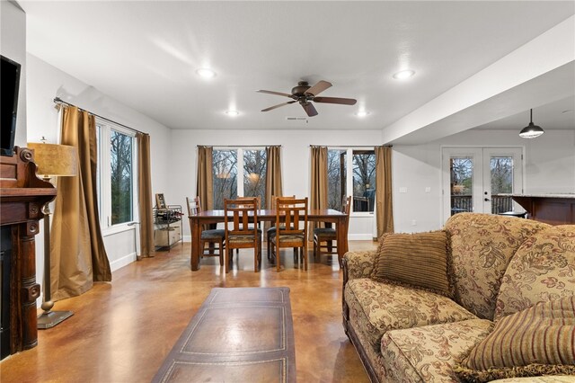 living room with concrete floors, ceiling fan, and french doors