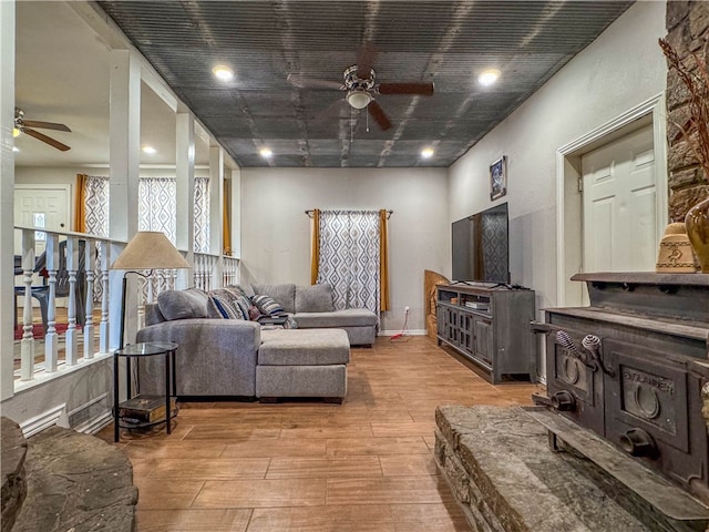 living room featuring light hardwood / wood-style floors, a healthy amount of sunlight, and ceiling fan