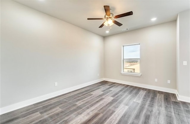 spare room featuring dark wood-type flooring and ceiling fan