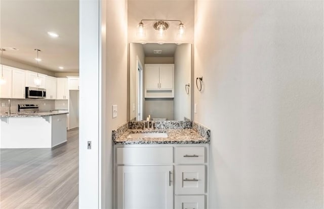 bathroom with backsplash, wood-type flooring, and sink