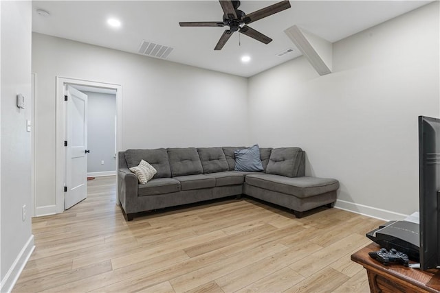 living room featuring light wood finished floors, visible vents, and a ceiling fan