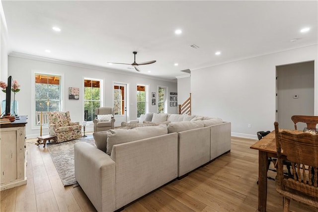 living area featuring a wealth of natural light, crown molding, light wood finished floors, and recessed lighting