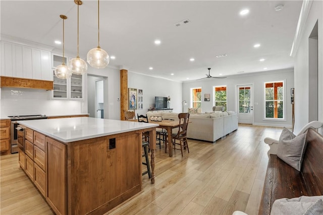 kitchen featuring open floor plan, stainless steel electric range oven, and light wood finished floors