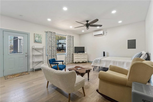 bedroom featuring recessed lighting, a wall mounted air conditioner, electric panel, and light wood-style floors