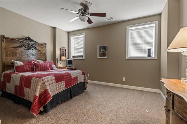 bedroom with multiple windows, ceiling fan, and carpet floors