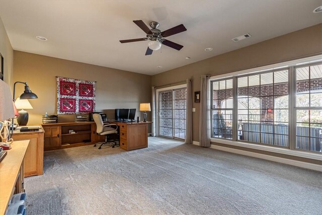 carpeted office with ceiling fan