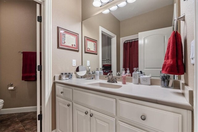 bathroom with toilet, vanity, and tile patterned floors