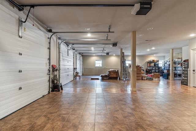 garage with wood walls and a garage door opener