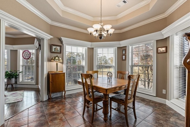 dining area featuring a chandelier, a tray ceiling, and ornamental molding