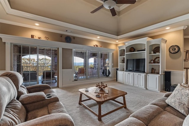 carpeted living room featuring a high ceiling, ceiling fan, a raised ceiling, and crown molding