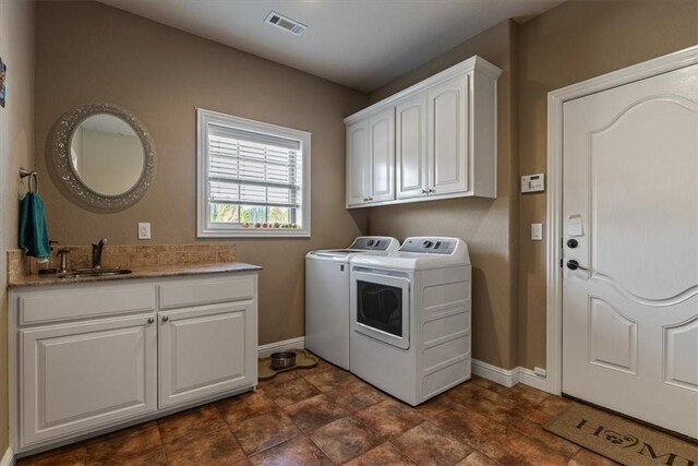 laundry room featuring cabinets, washing machine and dryer, and sink