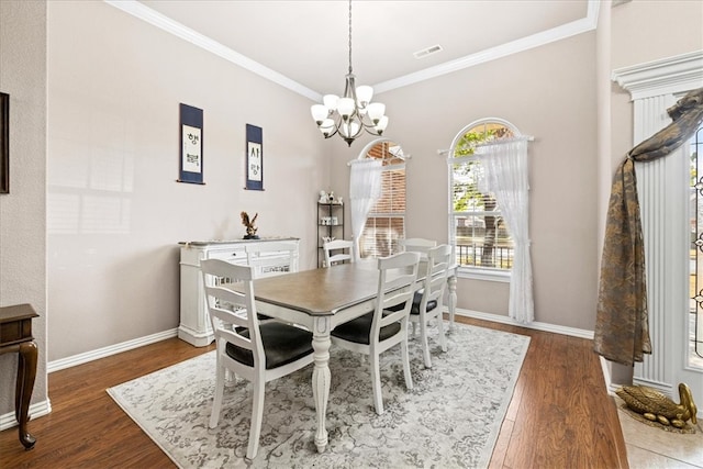 dining area featuring dark hardwood / wood-style flooring, crown molding, and an inviting chandelier