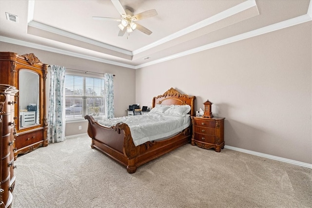 carpeted bedroom with ceiling fan, crown molding, and a tray ceiling