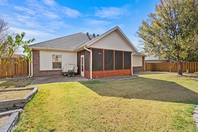 back of house featuring a yard and a sunroom