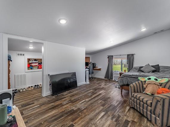 bedroom featuring dark wood-type flooring and vaulted ceiling