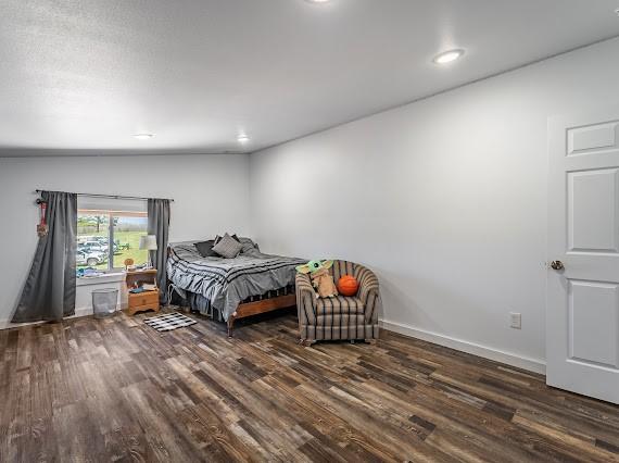 bedroom with vaulted ceiling and dark hardwood / wood-style flooring