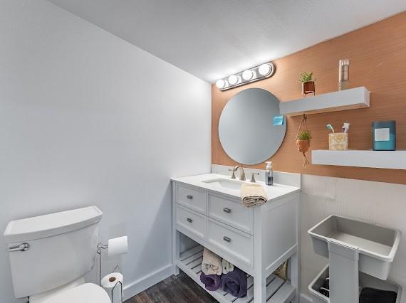 bathroom with vanity, toilet, and hardwood / wood-style flooring