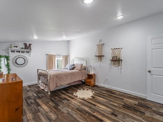 bedroom with dark hardwood / wood-style floors and vaulted ceiling