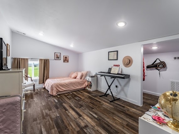 bedroom featuring dark wood-type flooring and vaulted ceiling